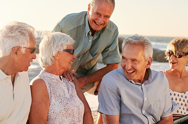 59_Brochure_0002_group-of-senior-friends-sitting-on-rocks-by-sea-on-QXUV3F5